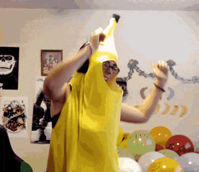 a man in a banana costume is holding a banana on his head