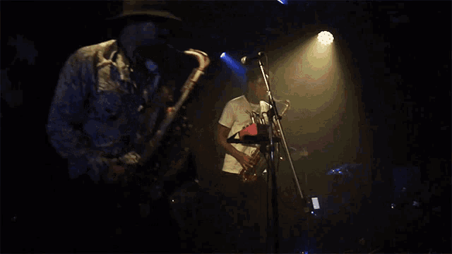 a man is playing a saxophone in front of a microphone