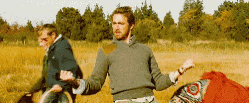a group of people are standing in a field .