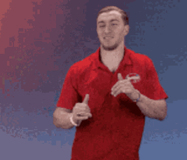 a man in a red shirt giving a thumbs up sign
