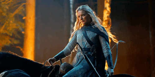 a woman with long blonde hair is riding a black horse