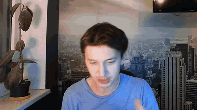a man in a blue shirt is standing in front of a picture of a city