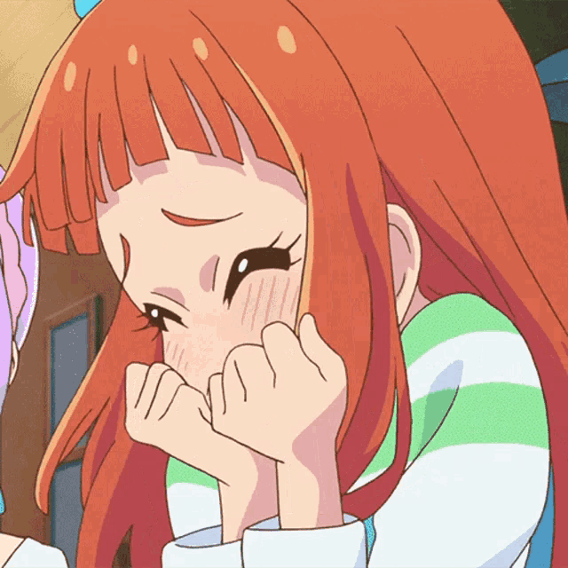 a close up of a girl with red hair covering her face with her hands