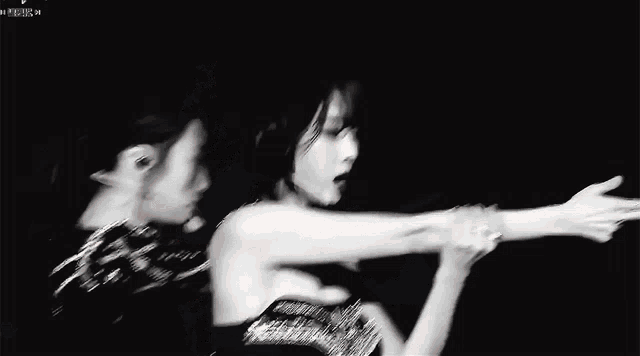 a black and white photo of two women dancing on stage .