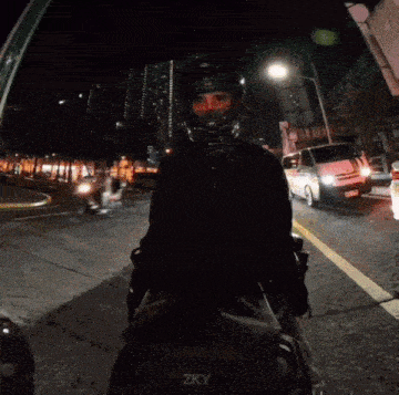 a person wearing a helmet is riding a motorcycle down a street