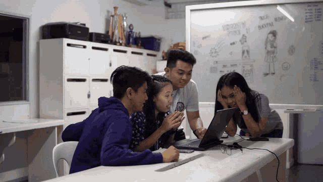 a group of people looking at a laptop with a whiteboard behind them that says ' women 's fire '