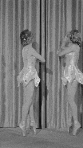 a black and white photo of three women dancing in a room