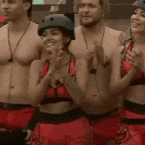 a group of people are standing next to each other applauding .