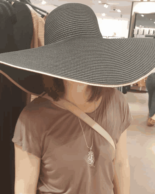 a woman is wearing a large black hat
