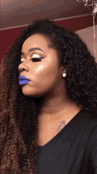 a woman with purple lipstick is wearing earrings