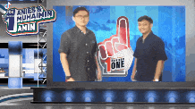 two men are standing in front of a sign that says 1 on it