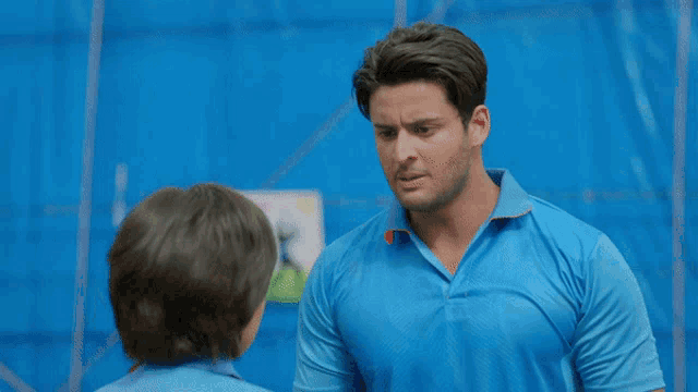 a woman in a blue shirt is looking down at something