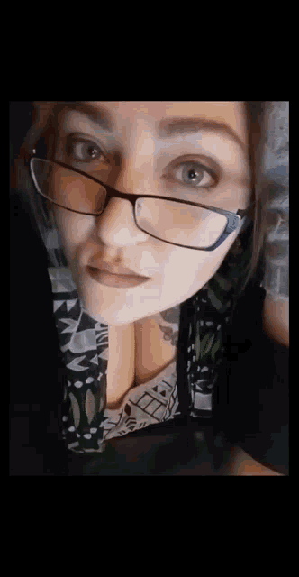a woman wearing glasses looks at the camera