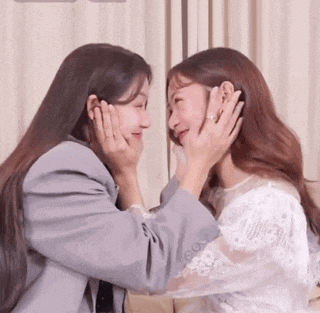 two women are touching each other 's faces .