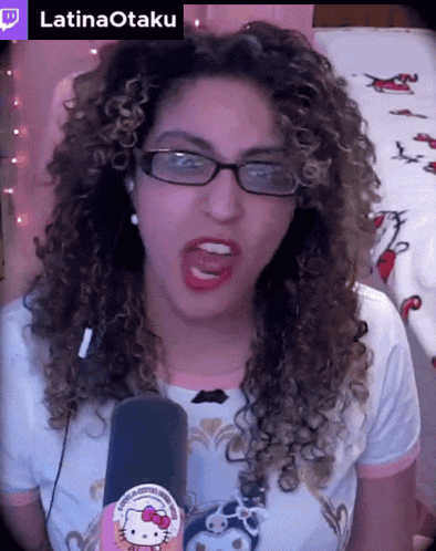 a woman with curly hair is wearing glasses and a hello kitty sticker