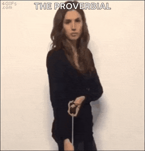 a woman in a black dress is holding a sword in her hand and says `` the proverbial '' .