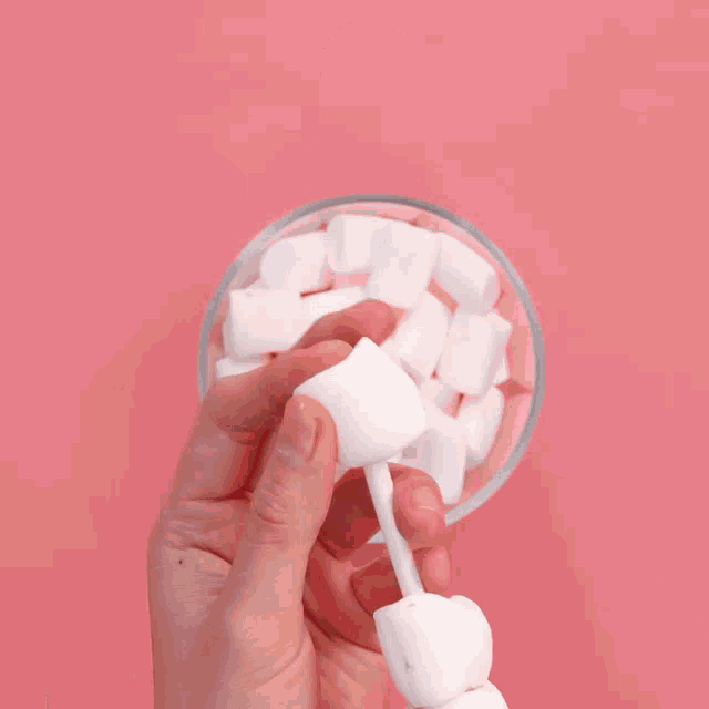 a glass of dark chocolate with marshmallows floating in it