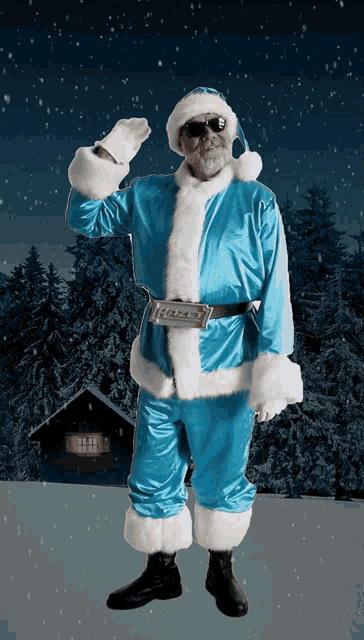 a man dressed as santa claus stands in front of a snowy cabin