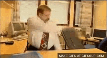 a man is sitting at a desk in front of a computer with the words make gifs at gifsoup.com visible