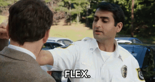 a police officer is talking to another man and flexing his arms