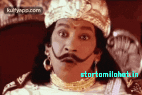a man with a crown on his head and a mustache is sitting in front of a starttamilchat.com website