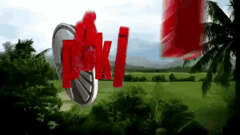 a blurred image of a field with a palm tree in the foreground and a red sign that says pki
