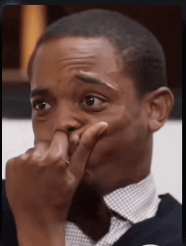 a man is covering his face with his hand and making a funny face