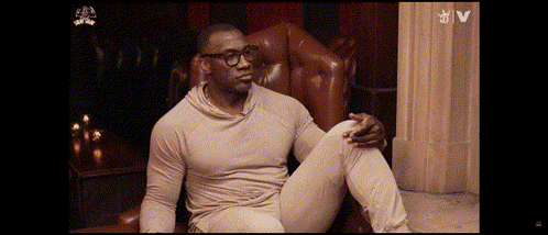 a man wearing glasses is sitting in a chair