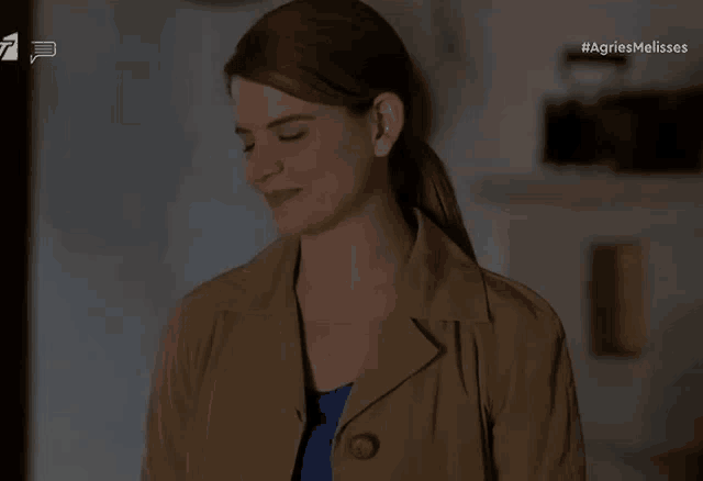 a woman in a trench coat with the hashtag agriesmelisses on the screen