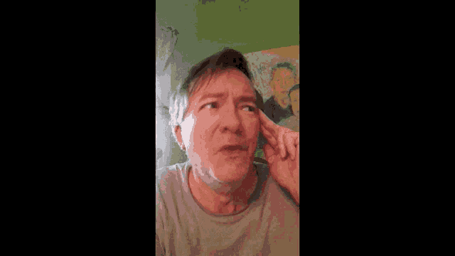 a man is making a funny face in front of a painting of vincent van gogh