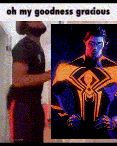 a man in a black shirt is standing next to a picture of a spiderman .