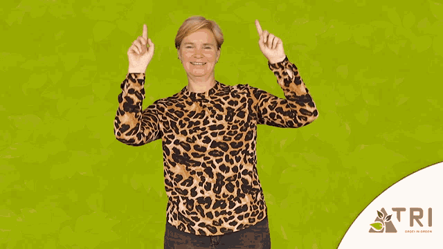 a woman wearing a leopard print shirt points upwards