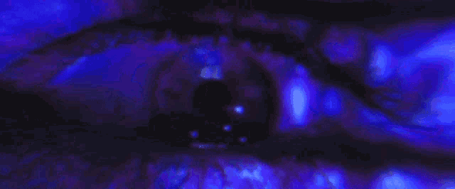 a close up of a person 's eye with a blue light behind it .