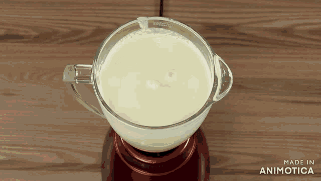 a blender is filled with a white liquid and the words made in animotica are on the bottom