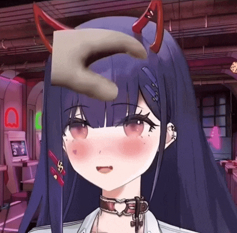 a hand is holding a piece of paper on the forehead of a girl with horns .