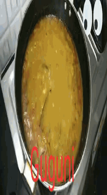 a pot of curry is being cooked on a stove with the word gumbo in red