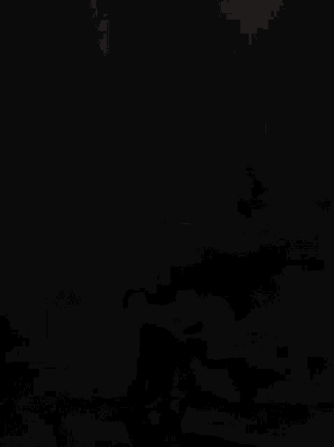 a blurry picture of a man holding a sword in a dark room