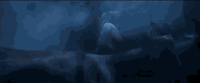 a man with a beard is standing in a dark room with smoke coming out of his mouth .