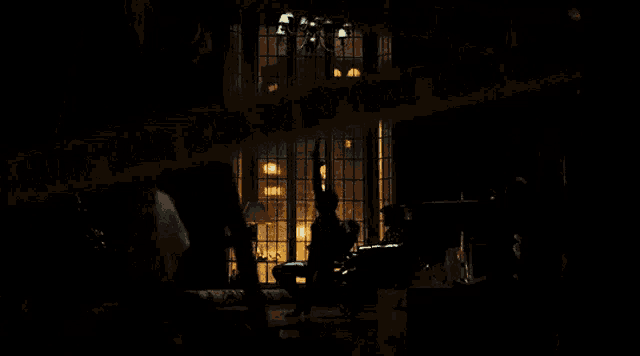 a group of people are standing in a dark room .