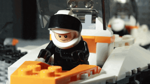 a lego figure wearing a helmet and gloves