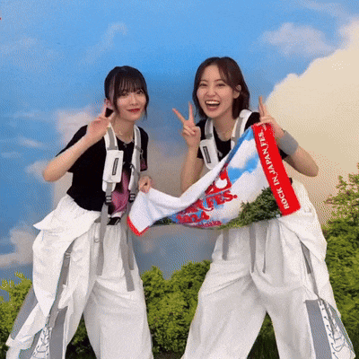 two women holding a towel that says " made in japan " on it