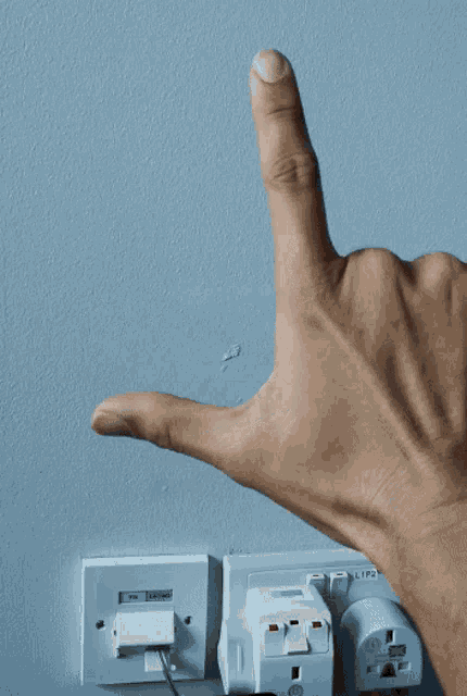 a person 's hand pointing at a socket that says ' input '