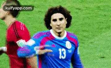 a soccer player wearing a blue jersey with the number 13