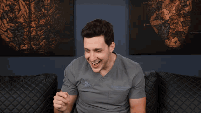 a man wearing a grey scrub top that says dm on the front