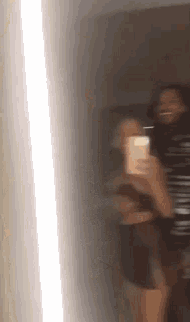 two people are taking a selfie in front of a mirror .