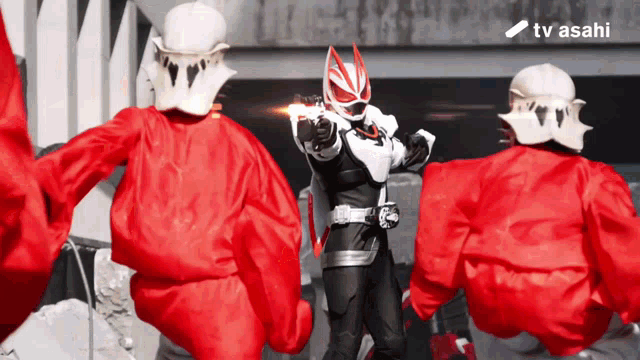 a man in a superhero costume is pointing a gun at someone in a red jacket