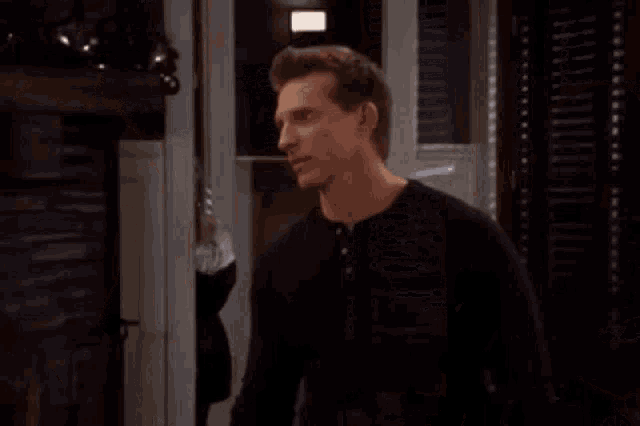 a man and a woman are standing next to each other in a living room .
