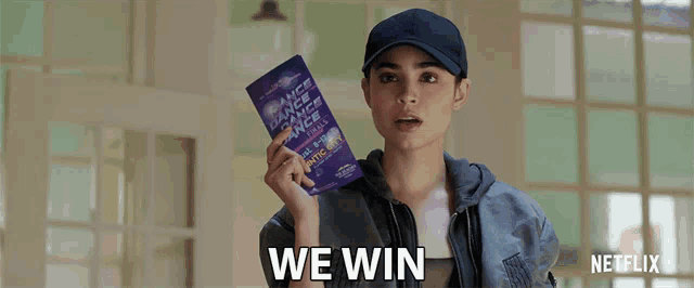 a woman is holding a book that says " we win "