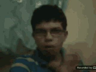 a blurry picture of a young man with glasses and a recorded by m logo