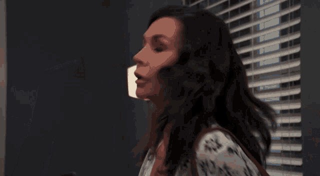 a woman is holding a cell phone and looking at a man